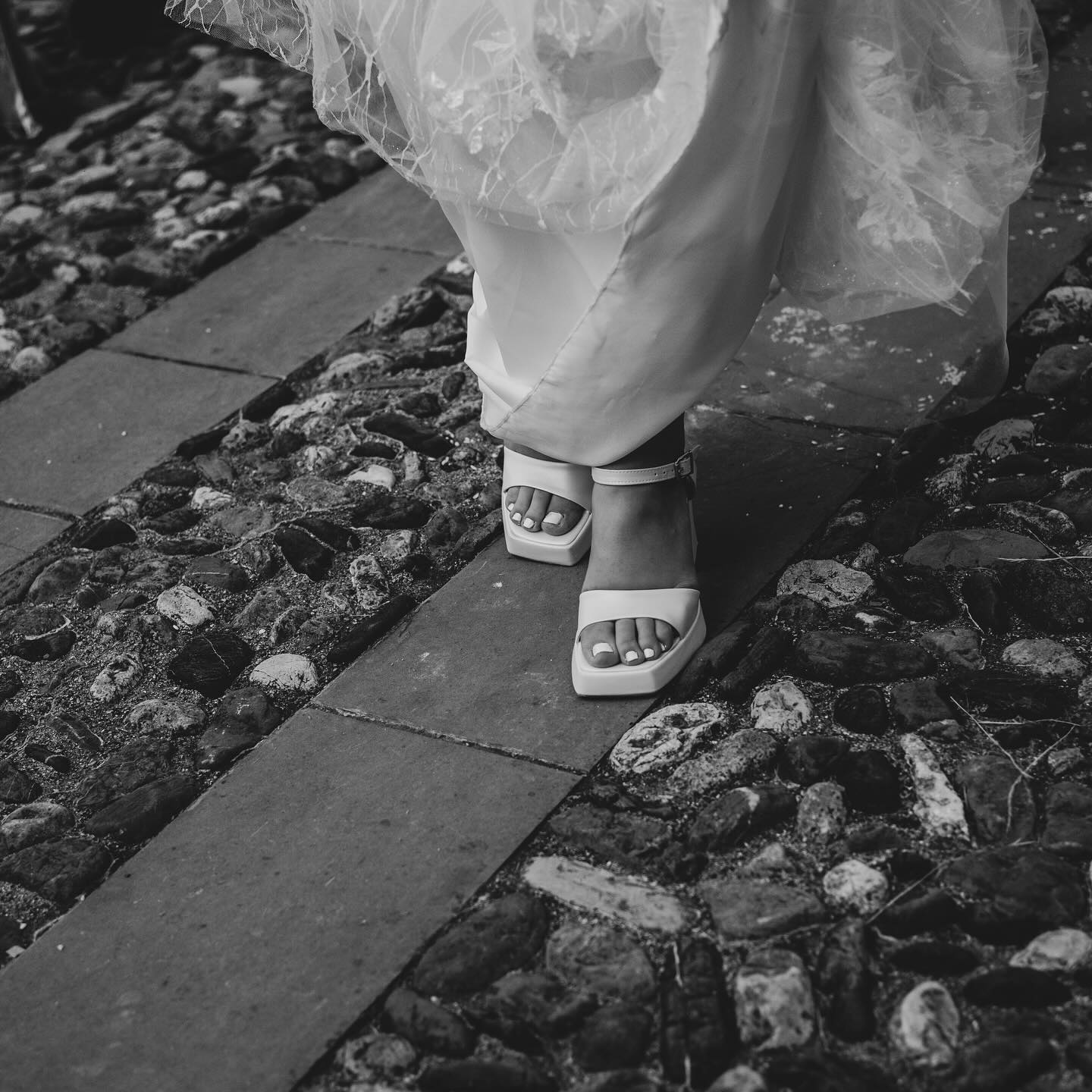 Scarpe della sposa su un vicolo di ciottoli