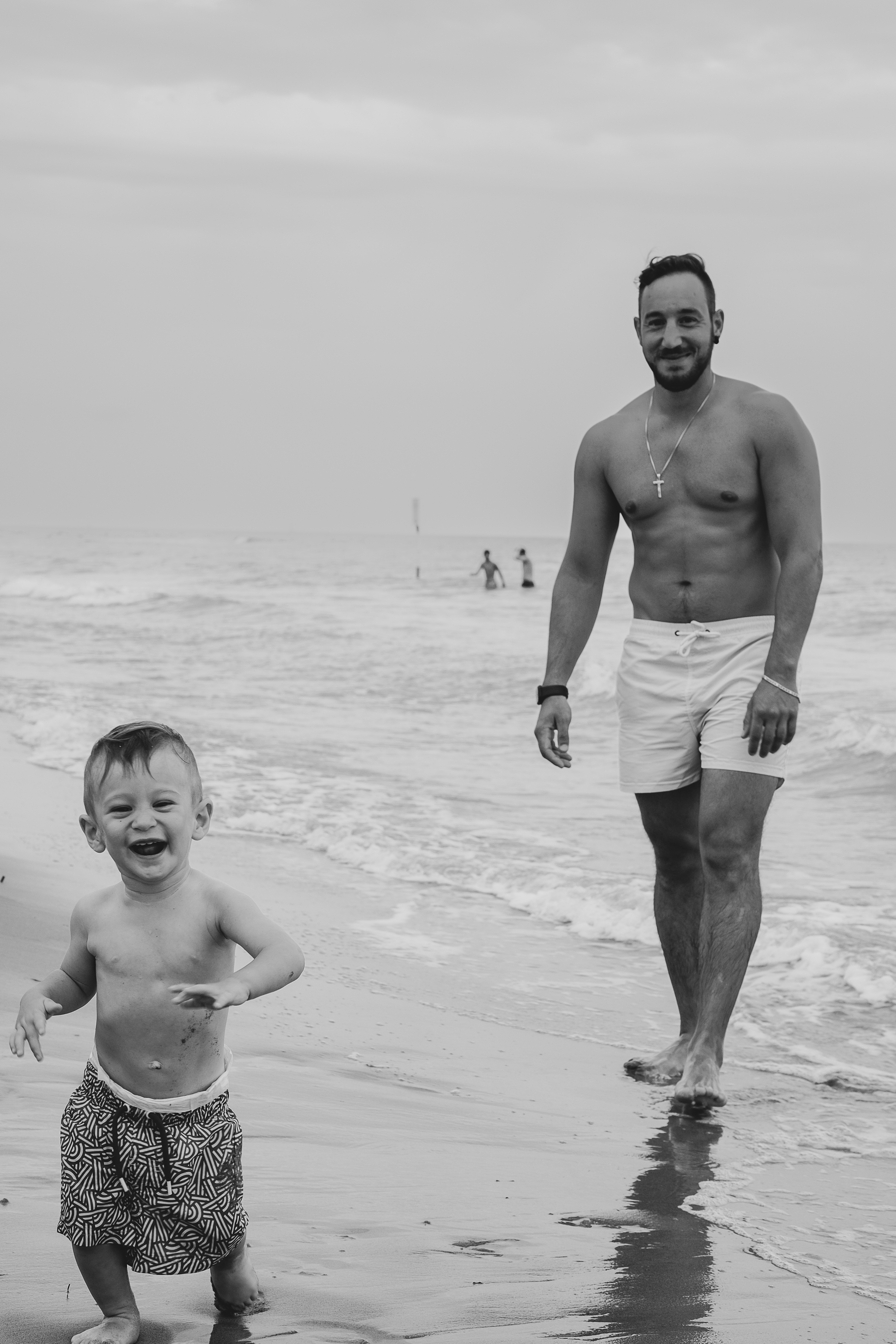Padre e figlio che ridono in riva al mare